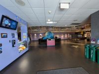 wide angle color image of the planetarium as you walk in with a big earth globe in front of you, trash cans to the right and a register to the left.