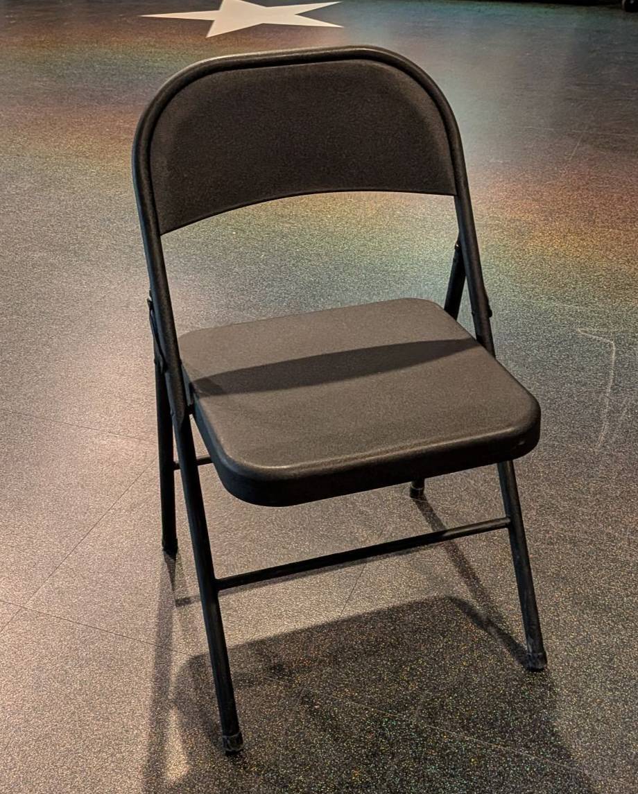 Image of black folding chair in the middle of the planetarium lobby