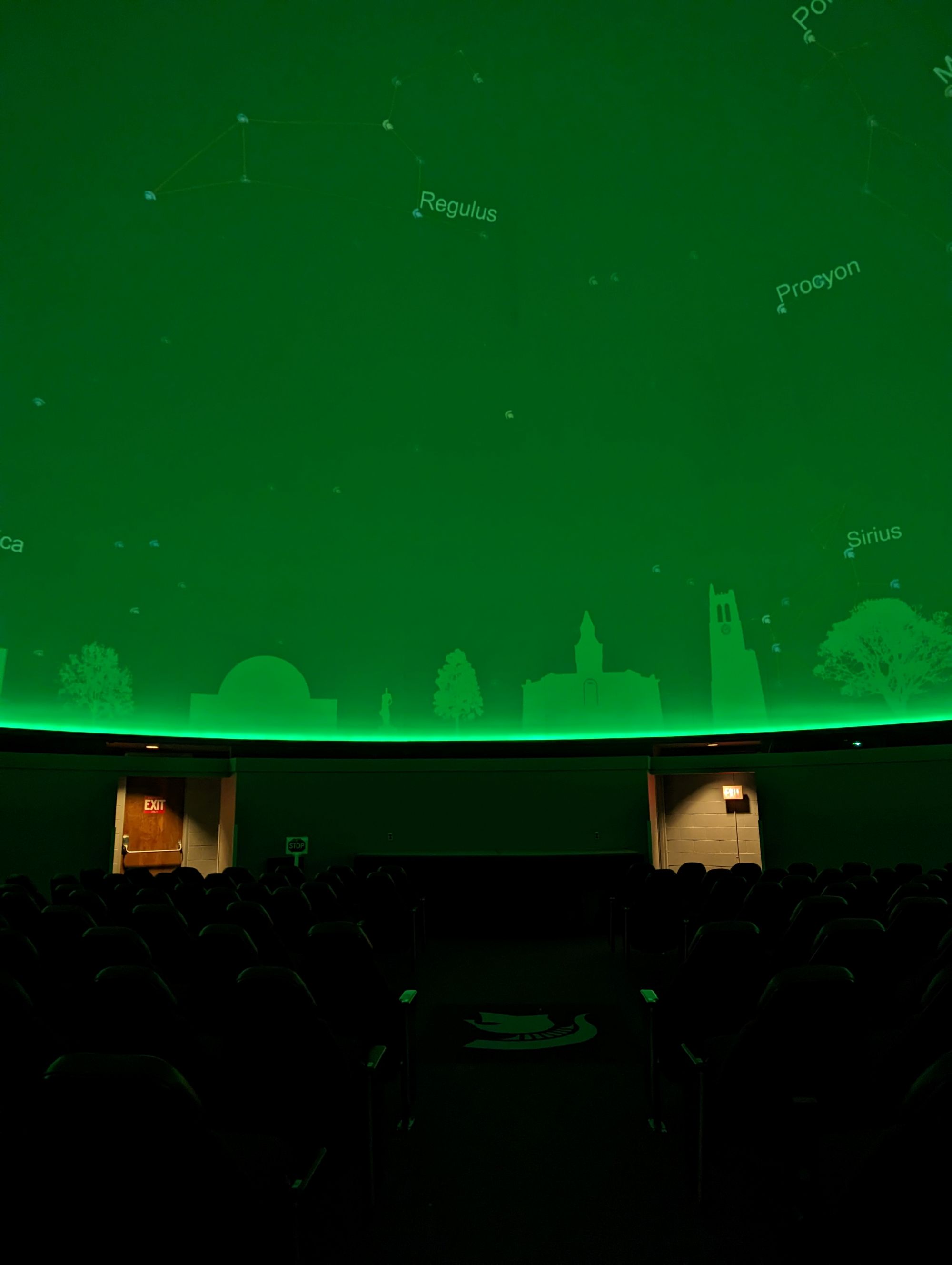 Planetarium dome with silhouette of MSU buildings along horizon