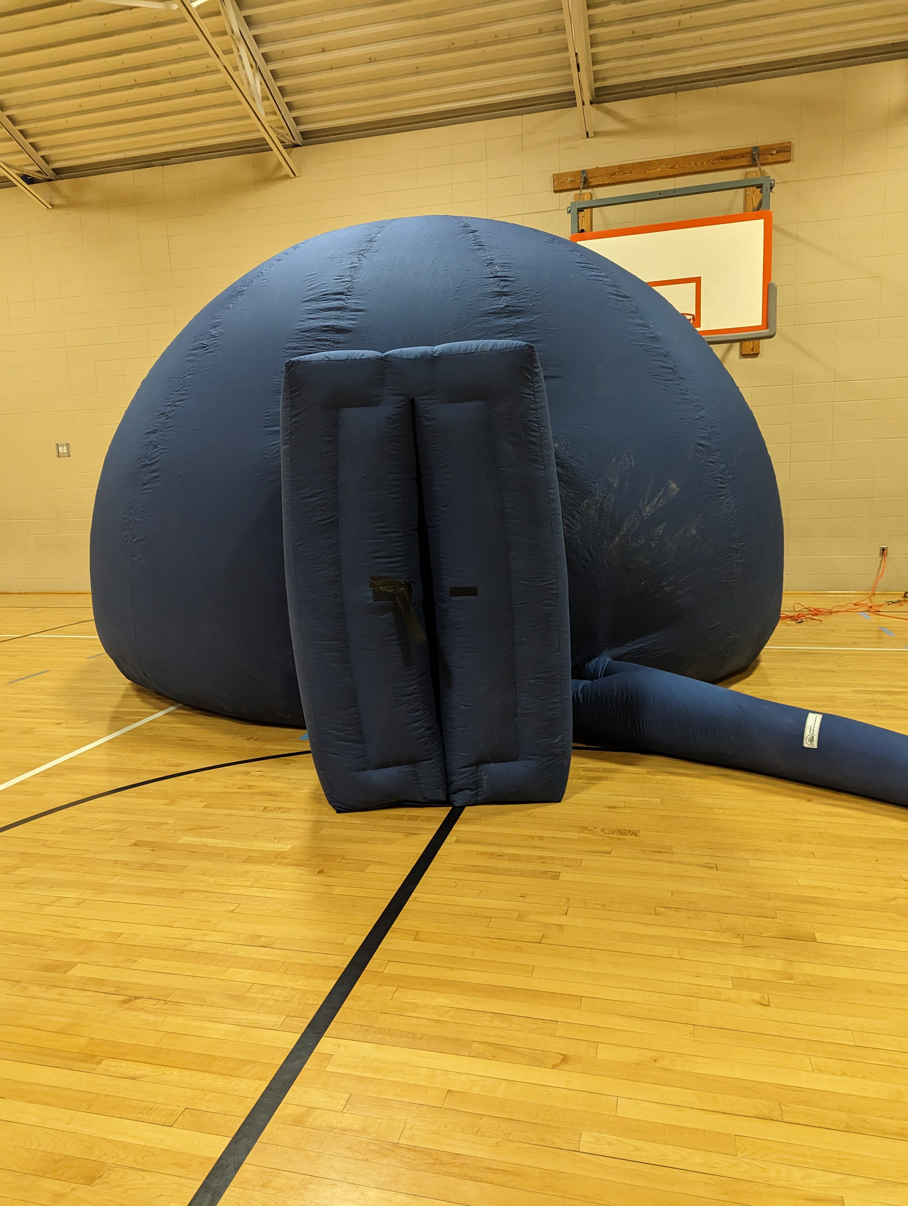 Blue inflatable dome with attached fan in a gym