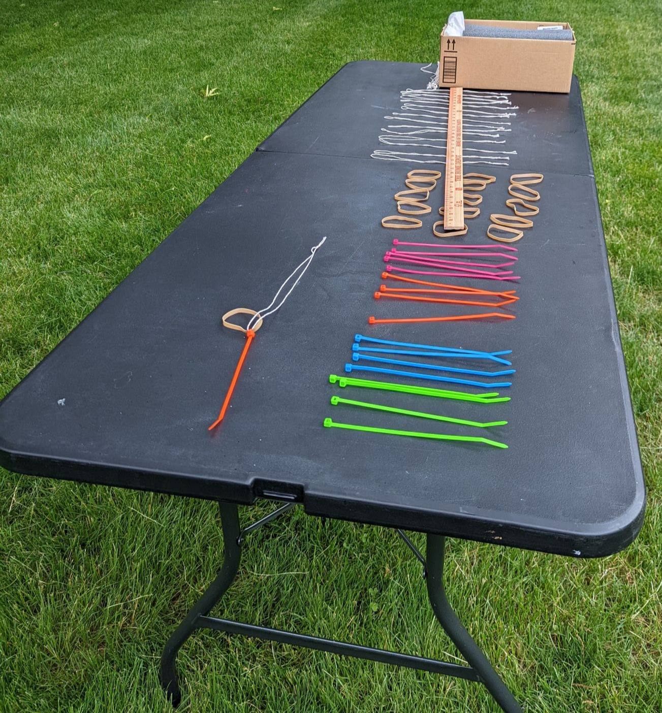 Image of black table as seen from a short end outside with activity supplies